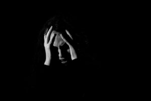 Grayscale photo of woman covering her face in shame