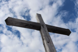 Low-angle photography of gray cross against clouds symbolizing the freedom Christian Counselling Calgary seeks to bring