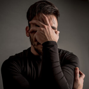 calgary counselling services grieving client covering his face with his hand